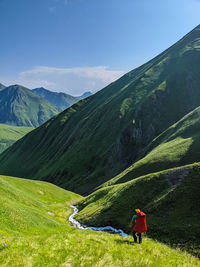 Rear view of man on mountain against sky