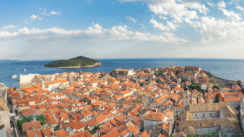 High angle view of city by sea against sky