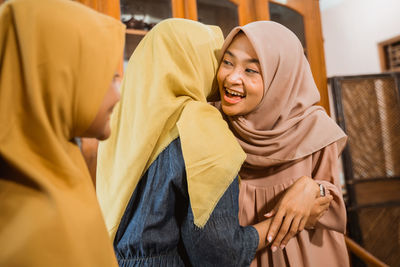Happy women in hijab embracing at home