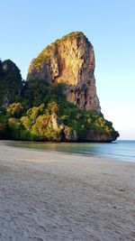 Rock formation on beach against sky