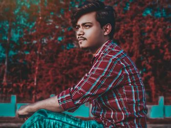 Portrait of young man looking away outdoors