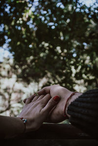 Cropped image of people holding hands outdoors