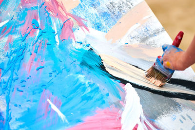 Drip painting expression art on canvas with blue, pink and beige colors, artist art performance