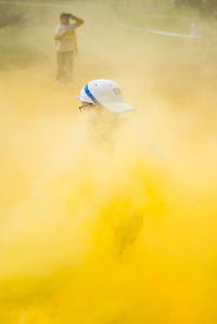 Close-up of boy enjoying with yellow powder paint