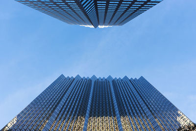 Low angle view of modern buildings against blue sky