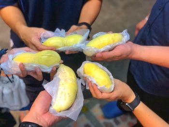 Midsection of people holding ice cream