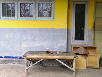 Empty chairs and tables in street against building