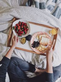 High angle view of woman having breakfast on bed