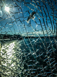 Full frame shot of wet spider web against blue sky