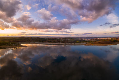 Drone aerial view of a lake reservoir of a dam with reflection on the water in sabugal, portugal