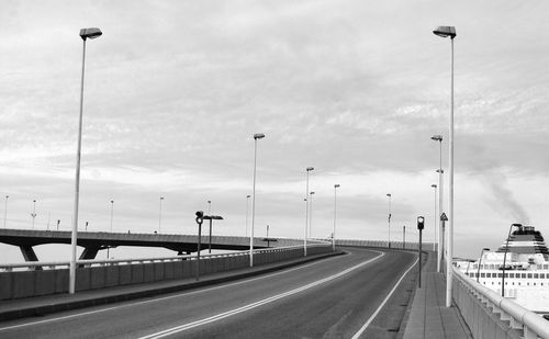 Vehicles on highway against sky in city