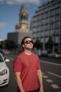 Portrait of young man wearing sunglasses standing in city