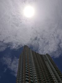 Low angle view of skyscrapers against cloudy sky
