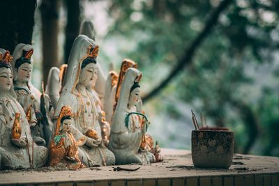 Close-up of shrine with statues against trees