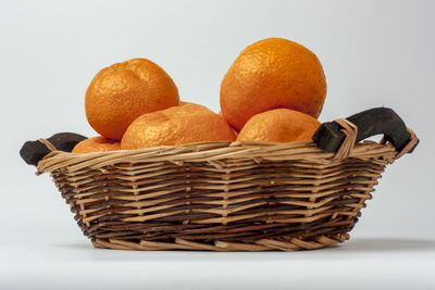 Close-up of fruits in basket against white background