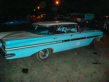 Side view of car parked on road at night