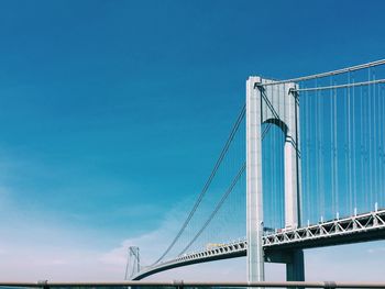 Low angle view of verrazano–narrows bridge against blue sky