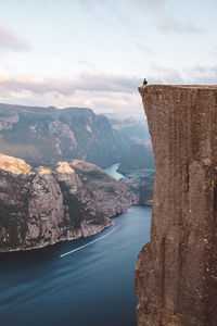 Man sitting at edge of cliff at preikestolen, norway