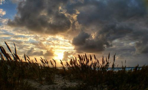 Scenic view of dramatic sky over land during sunset