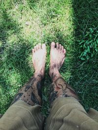 Low section of man standing on grass