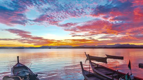 Boat moored in sea against sky during sunset