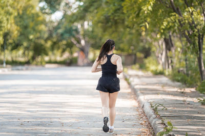 Rear view of woman walking on footpath