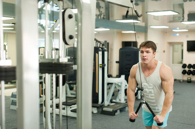 Young man exercising in gym