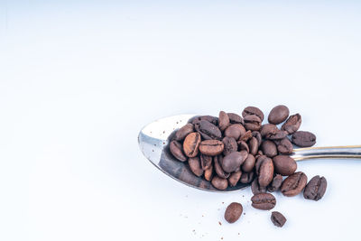 High angle view of coffee beans against white background