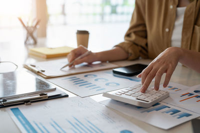Midsection of businessman working on table