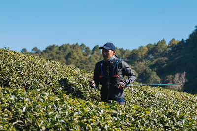 Man standing on field against clear blue sky