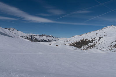 Scenic view of snowcapped mountains against blue sky