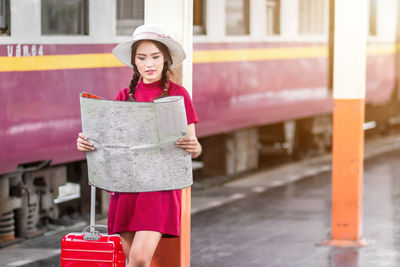 Portrait of smiling young woman standing in city