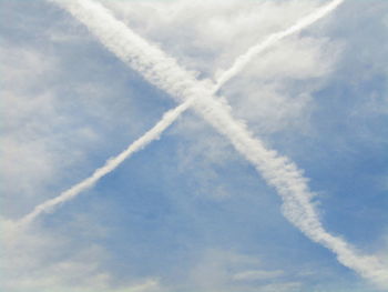 Low angle view of airplane flying against blue sky