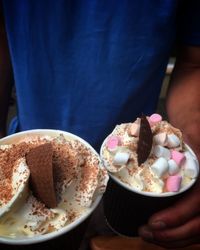 Close-up of hand holding ice cream in bowl