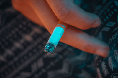 Close-up of hand holding cigarette