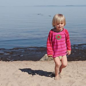Full length of girl walking on sand at beach against sea