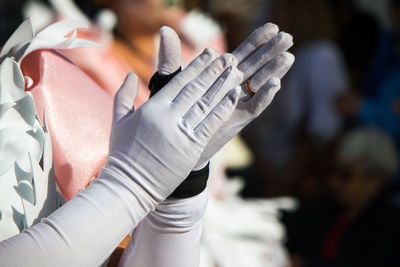 Close-up of hands with gloves applaud