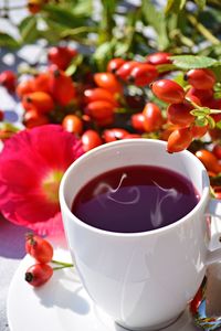 Close-up of coffee cup with red flowers