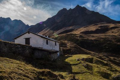 Scenic view of house and mountains against sky