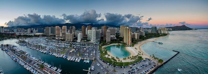 High angle view of city buildings against cloudy sky