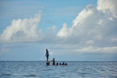 People on sea against sky