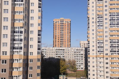 Buildings in city against clear blue sky