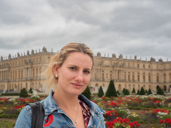 Portrait of young woman standing against sky
