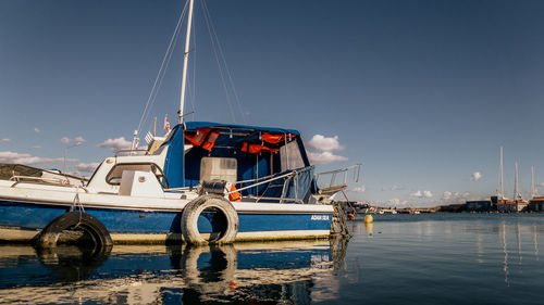 Ship moored at harbor against sky