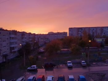 High angle view of traffic on road against buildings during sunset