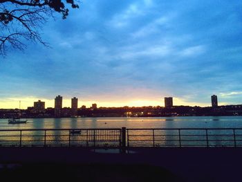 Sunset over river with buildings in background