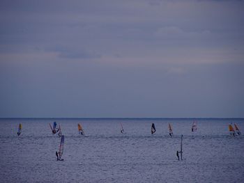 Tourists enjoying in sea against sky