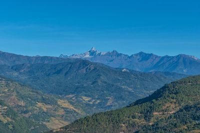 Scenic view of mountains against blue sky