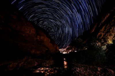 Low angle view of illuminated cave against sky at night