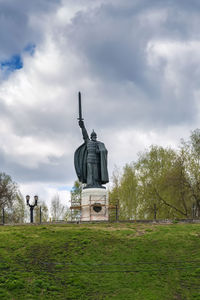 Statue on field against sky